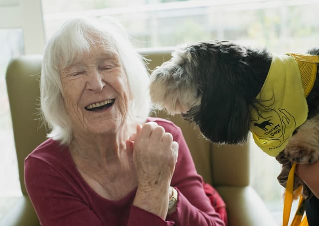 Older person sitting with their dog at home